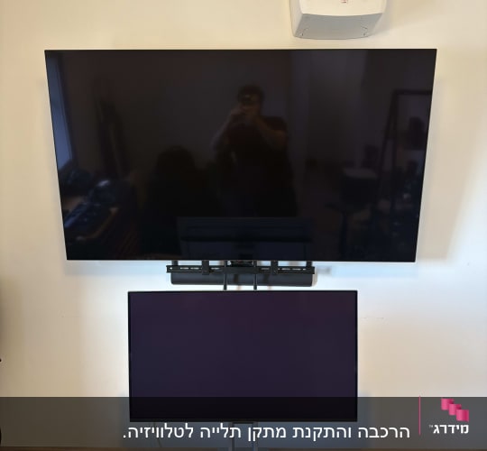 מסך טלוויזיה ומסך מחשב מותקנים על קיר